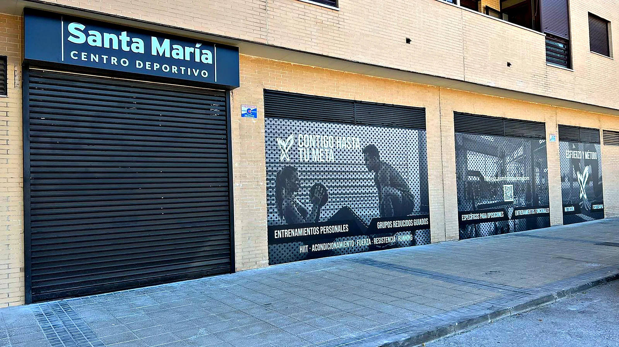 Fachada del centro deportivo Santa María con rótulo y vinilos